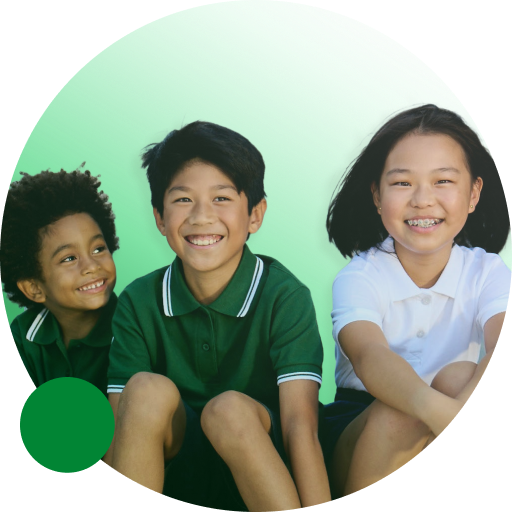 A diverse group of three primary aged children smiling in their green school uniform.
