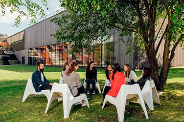 Group of people sitting on chairs in a circle in the garden